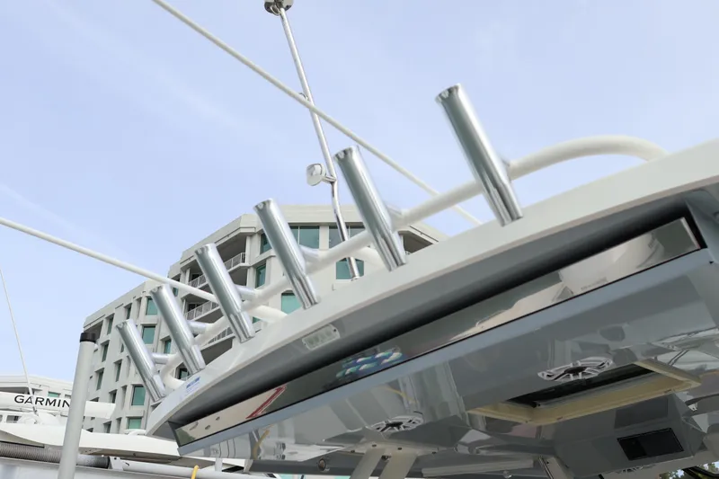 Slide: The Image of 2021 Pursuit S 328 Sport boat with rod holders, modern design, and urban backdrop. - 44