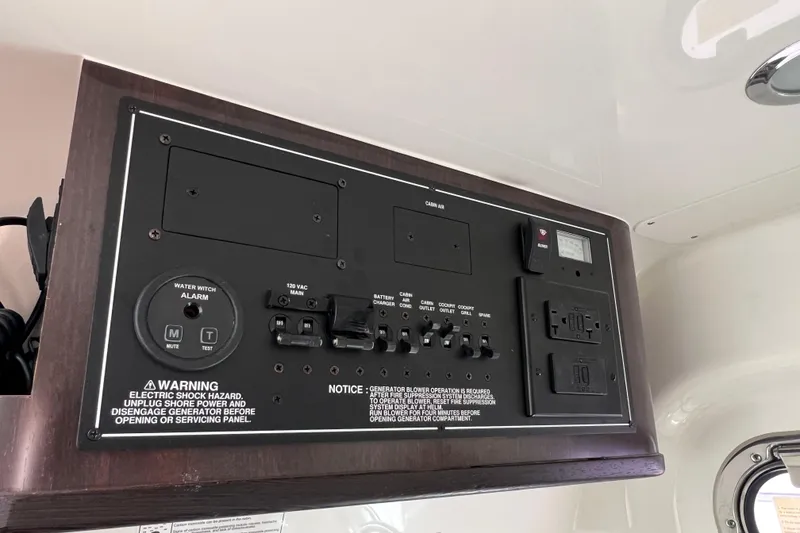 Slide: The Image of Electrical control panel on 2021 Pursuit S 328 Sport boat, featuring switches and warnings. - 57