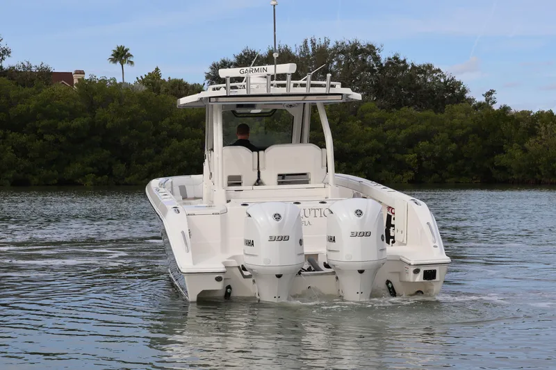 Slide: The Image of 2021 Pursuit S 328 Sport boat with dual Yamaha engines on a calm waterway. - 6