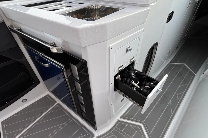 Slide: The Image of 2026 Monterey 385 Super Express boat interior with open storage drawer and sink. - 30