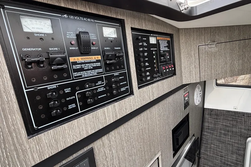 Slide: The Image of Control panel of a 2026 Monterey 385 Super Express boat, featuring electrical switches and gauges. - 61