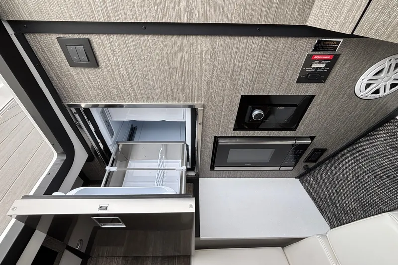Slide: The Image of 2026 Monterey 385 Super Express interior with fridge, microwave, and control panel. - 71