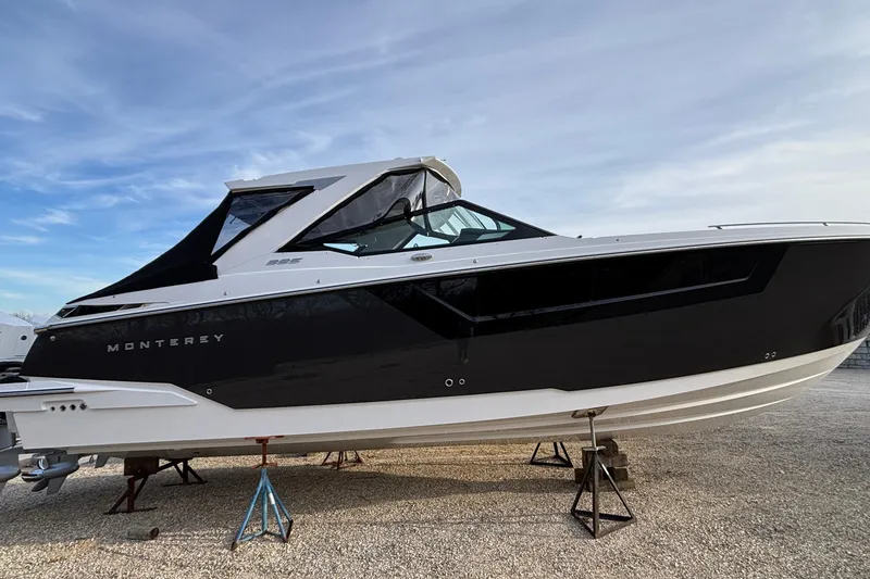 The Image of 2026 Monterey 385 Super Express boat on stands, sleek black and white design. - 1