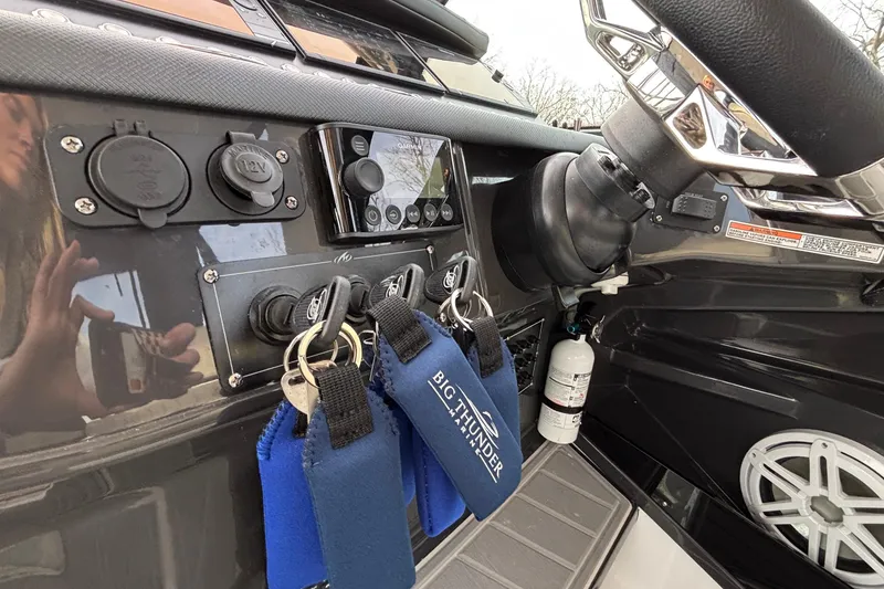 Slide: The Image of Control panel of 2026 Monterey 385 Super Express boat with keys and steering wheel. - 14