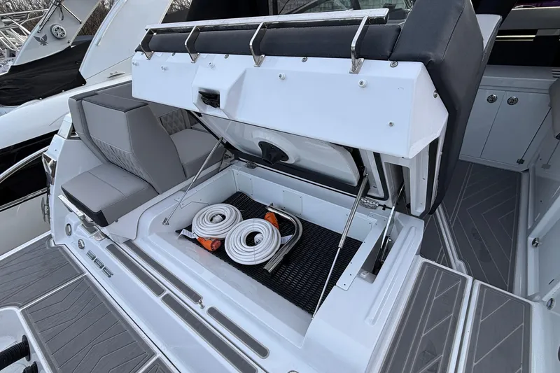 Slide: The Image of 2026 Monterey 385 Super Express boat with open storage compartment and coiled hoses. - 51