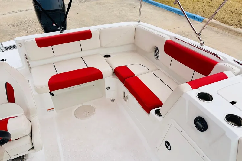Slide: The Image of 2021 Tahoe 1950 boat interior with red and white seating, cup holders, and speaker. - 27