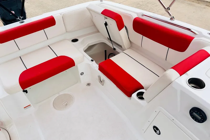 Slide: The Image of 2021 Tahoe 1950 boat interior with red and white seating, cup holders, and storage compartments. - 29
