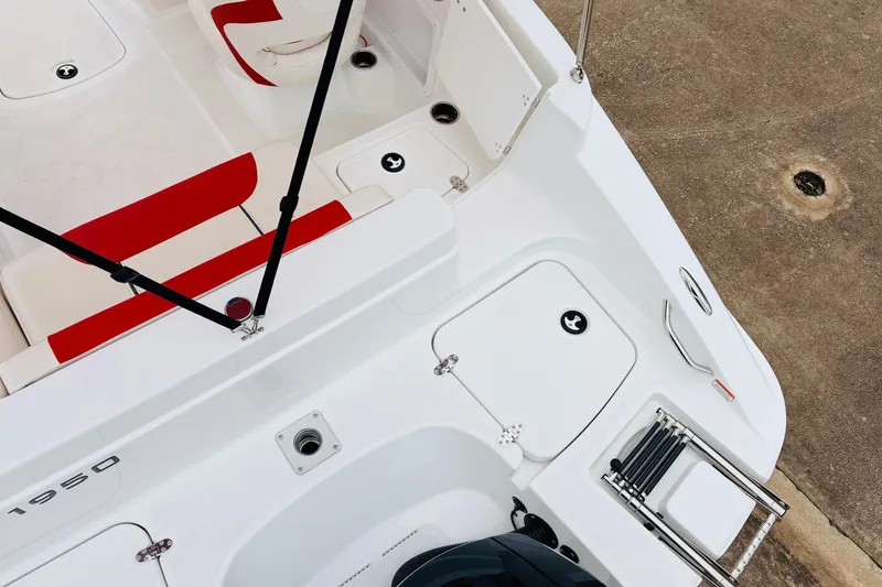 Slide: The Image of 2021 Tahoe 1950 boat interior with red and white seating, storage compartments, and ladder. - 44