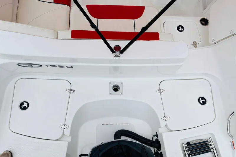 Slide: The Image of 2021 Tahoe 1950 boat interior with red and white seating, storage compartments, and motor area. - 45