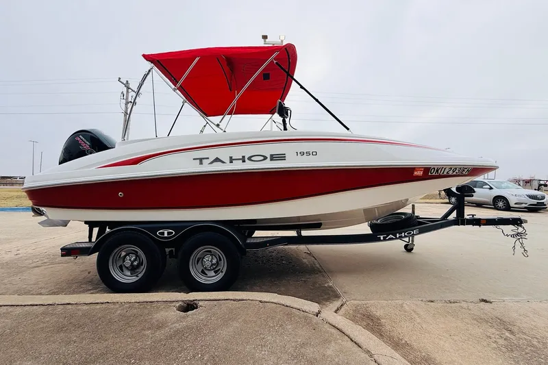 Slide: The Image of 2021 Tahoe 1950 boat with red canopy on trailer, parked outdoors. - 5