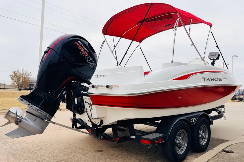 Slide: The Image of 2021 Tahoe 1950 boat with red canopy and powerful outboard motor on trailer. - 6