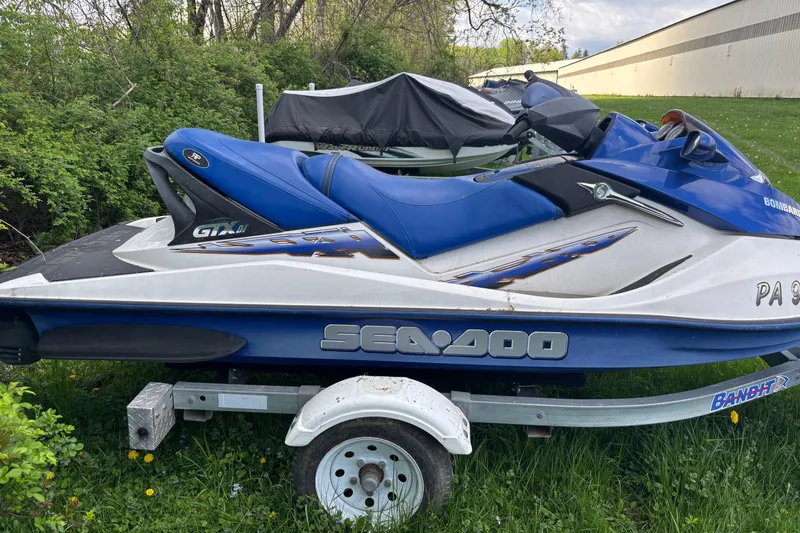 Slide: The Image of 2002 Sea-Doo GTX DI jet ski on trailer, parked on grass. - 4
