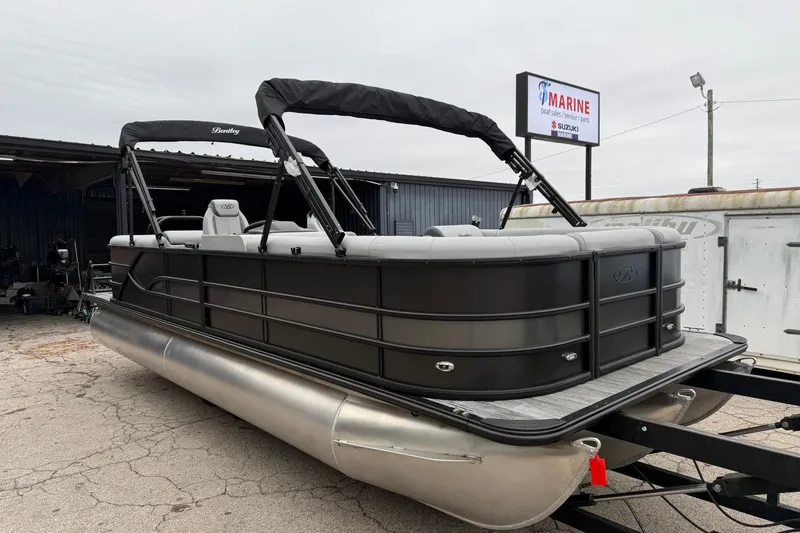 The Image of 2026 Bentley Pontoons Legacy 243 Navigator, sleek black design, parked at a marine service center. - 0