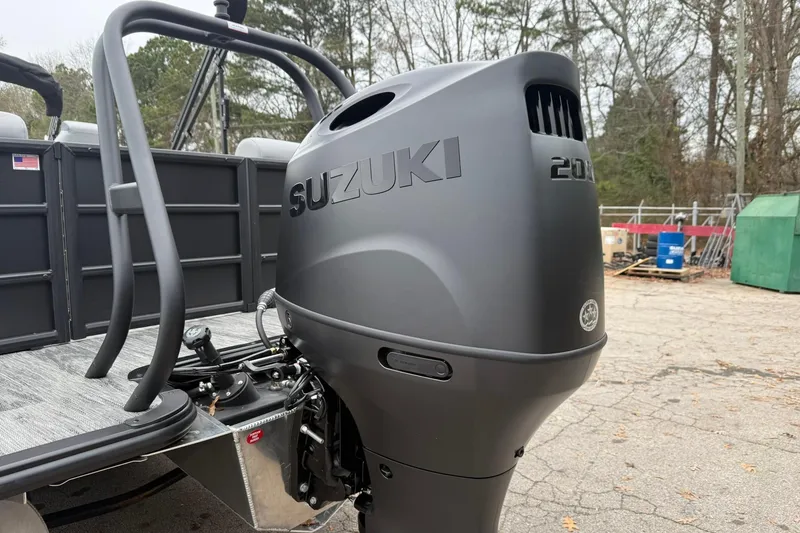 Slide: The Image of 2026 Bentley Pontoons Legacy 243 Navigator with Suzuki outboard motor in a wooded area. - 16