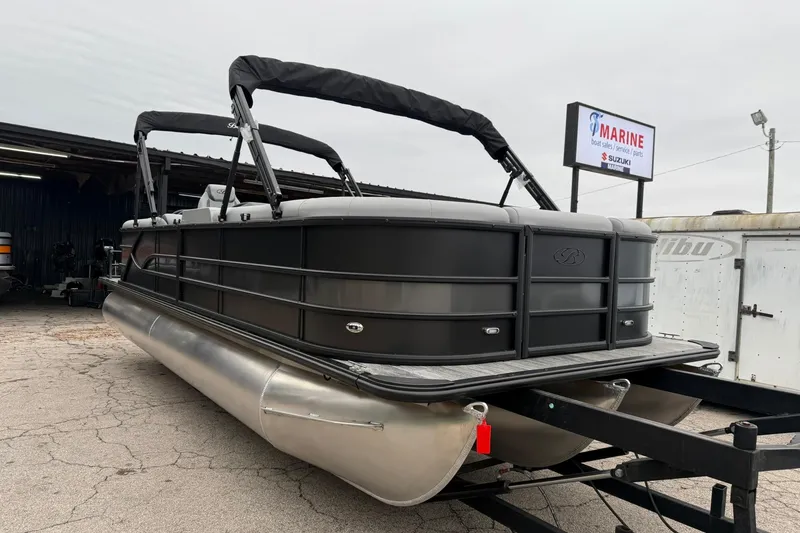 Slide: The Image of 2026 Bentley Pontoons Legacy 243 Navigator, sleek black design, parked at a marine dealership. - 17