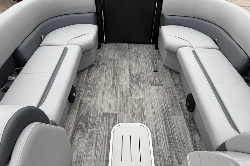 Slide: The Image of 2026 Bentley Pontoons Legacy 243 Navigator interior with gray seating and wood-style flooring. - 4