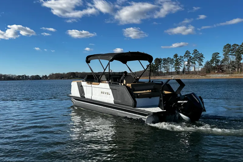 Slide: The Image of 2026 Revel RS25 boat cruising on a lake under a clear blue sky. - 12