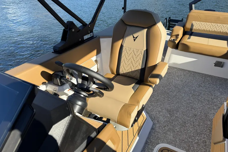 Slide: The Image of 2026 Revel RS25 boat interior with tan leather seats and steering wheel, on water. - 20