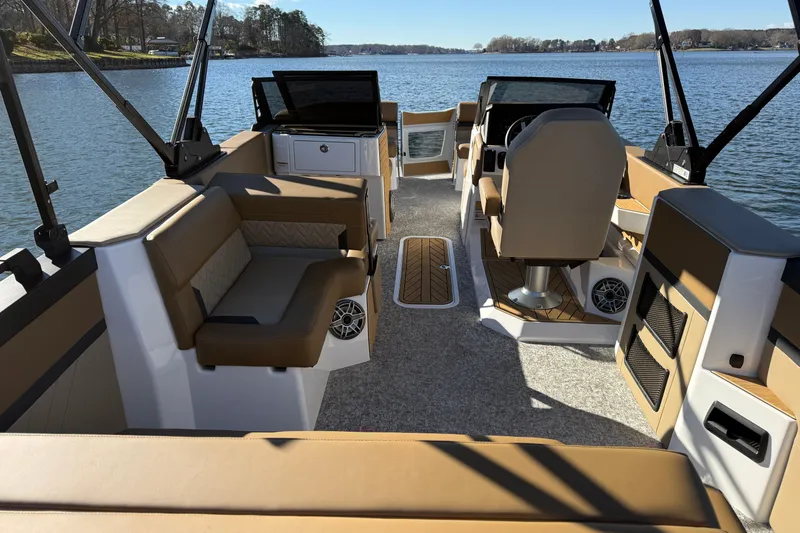 Slide: The Image of 2026 Revel RS25 boat interior with tan seating, steering console, and lake view. - 23
