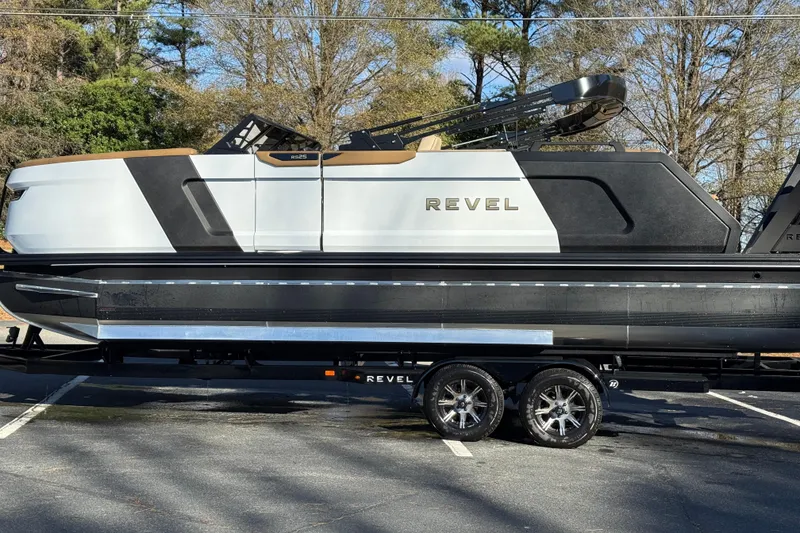 Slide: The Image of 2026 Revel RS25 boat on trailer, parked outdoors, showcasing sleek design and modern features. - 26
