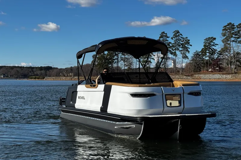 Slide: The Image of 2026 Revel RS25 boat cruising on a serene lake under a clear blue sky. - 5