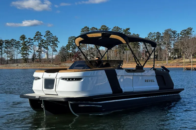 Slide: The Image of 2026 Revel RS25 boat on a serene lake with a clear blue sky. - 9