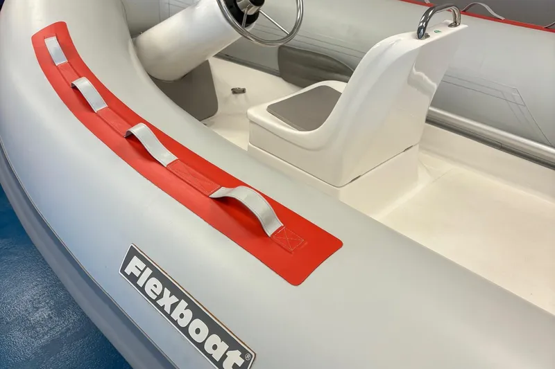 Slide: The Image of 2019 Flexboat SR12 SLX interior with steering console and red accents. - 3