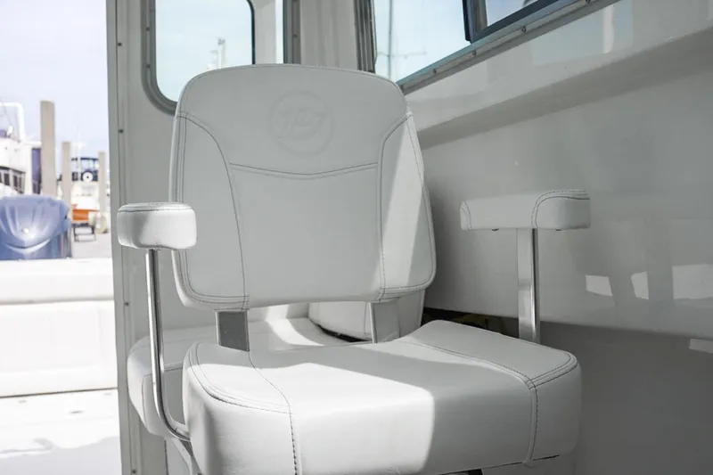 Slide: The Image of Manufacturer Provided Image: White captain's chair on 2026 Parker 227 Explorer boat, featuring sleek design and armrests. - 11