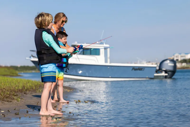 Slide: The Image of Children fishing by a Parker 227 Explorer boat, 2026 model, on a sunny day. - 5