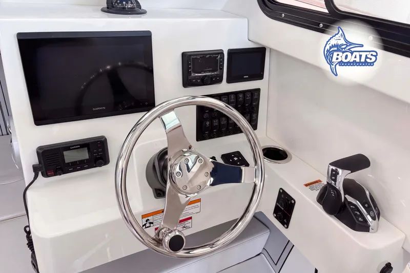 Slide: The Image of 2027 Parker 227 Explorer boat dashboard with steering wheel, Garmin displays, and control panel. - 5