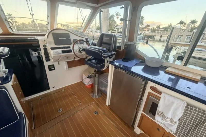 Slide: The Image of Interior of 2006 True North 38 boat with wooden flooring and navy seating. - 11