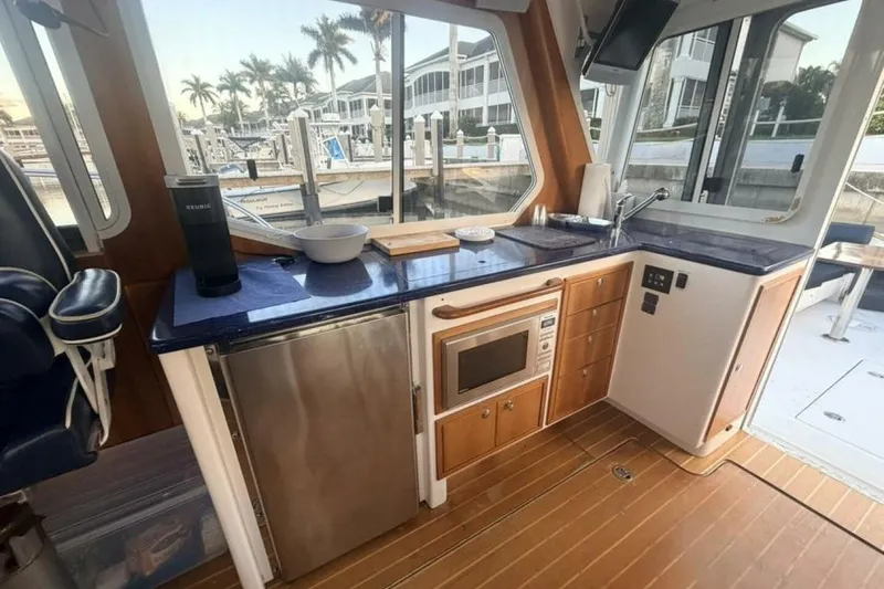 Slide: The Image of Interior of 2006 True North 38 boat with wooden paneling and blue cushioned seating. - 15