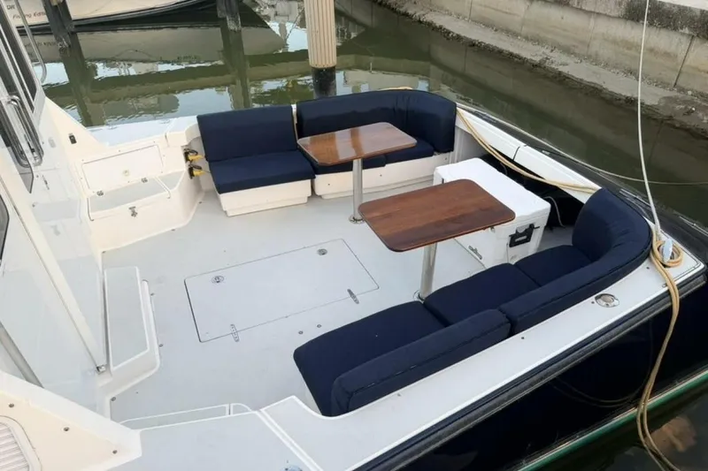 Slide: The Image of 2006 True North 38 boat with spacious outdoor seating and tables, docked at marina. - 18