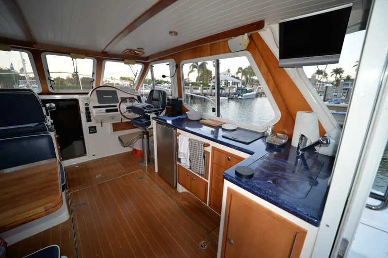 Slide: The Image of Interior of 2006 True North 38 boat with wooden table and navy seating. - 3