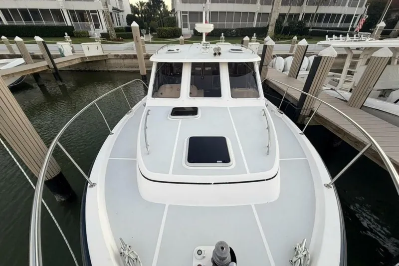 Slide: The Image of 2006 True North 38 boat docked at marina, surrounded by calm water and palm trees. - 9