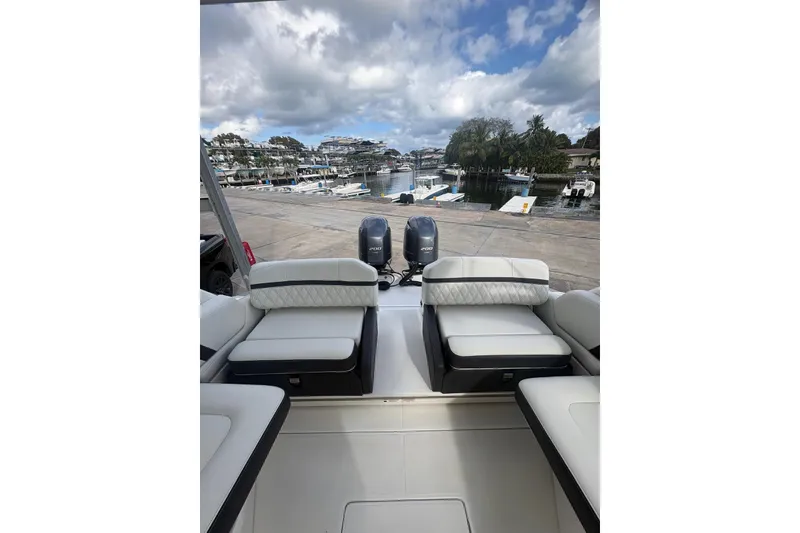 Slide: The Image of 2022 Regal 29 OBX boat with dual engines docked at a marina under cloudy skies. - 12