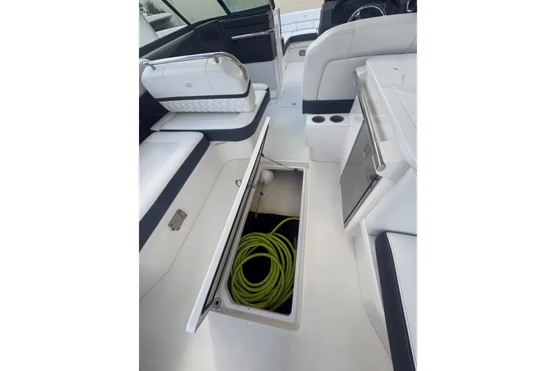Slide: The Image of 2022 Regal 29 OBX boat interior with open storage compartment and coiled rope. - 14