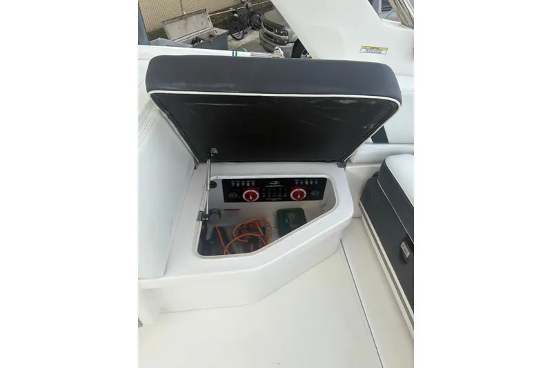 Slide: The Image of 2022 Regal 29 OBX boat storage compartment with open lid and visible controls. - 23