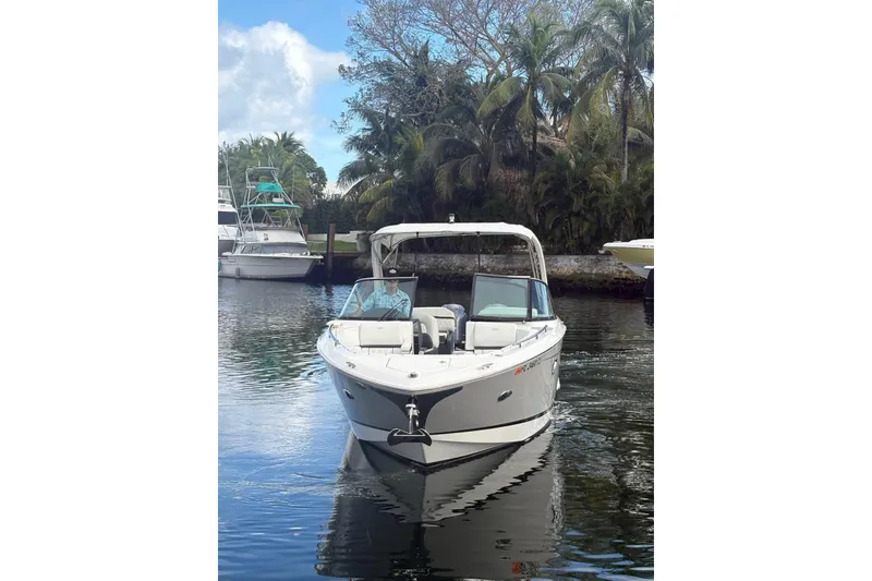 Slide: The Image of 2022 Regal 29 OBX boat on calm water, surrounded by lush greenery. - 3