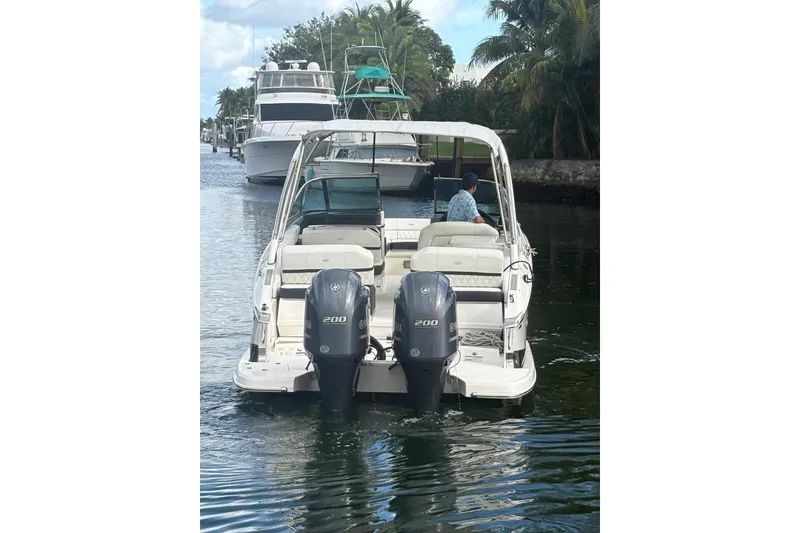 Slide: The Image of 2022 Regal 29 OBX boat with dual outboard engines cruising on a canal. - 4