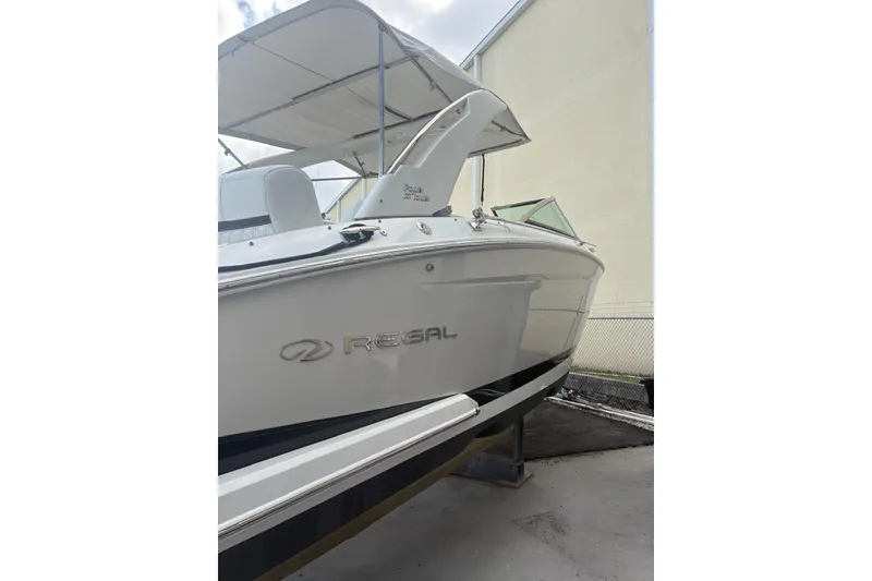 Slide: The Image of 2022 Regal 29 OBX boat with canopy, docked outdoors. - 5