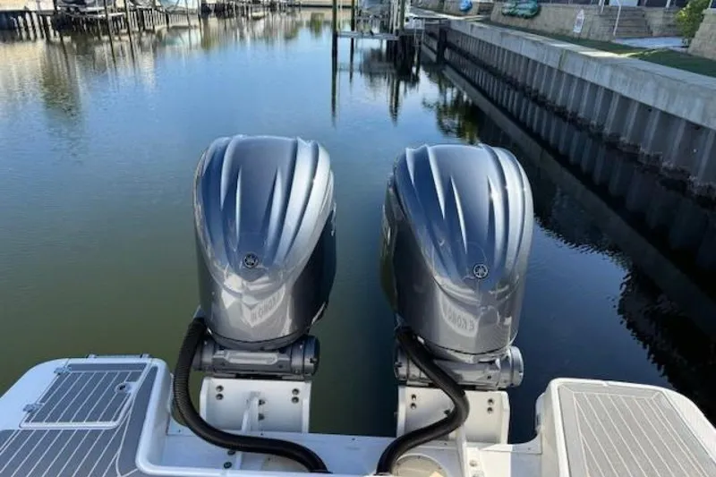 Slide: The Image of 2021 Robalo R317 Dual Console with twin outboard engines on calm water. - 10