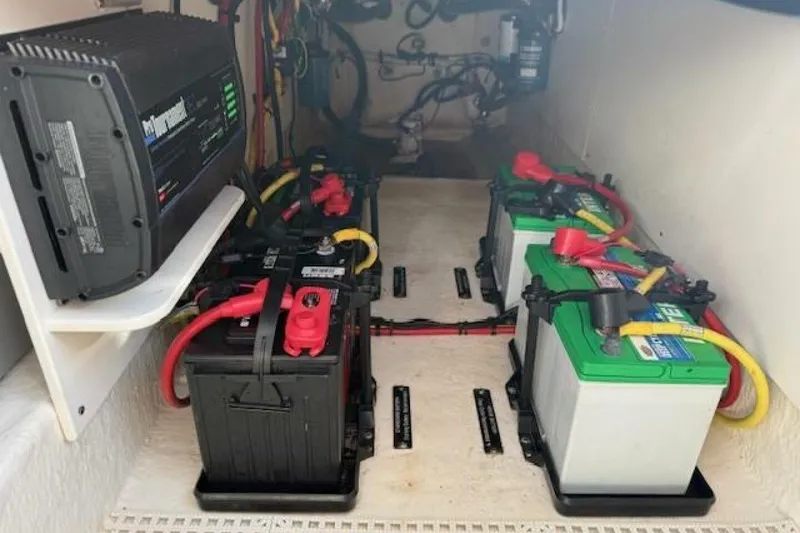 Slide: The Image of 2021 Robalo R317 Dual Console boat battery compartment with multiple batteries and wiring. - 11