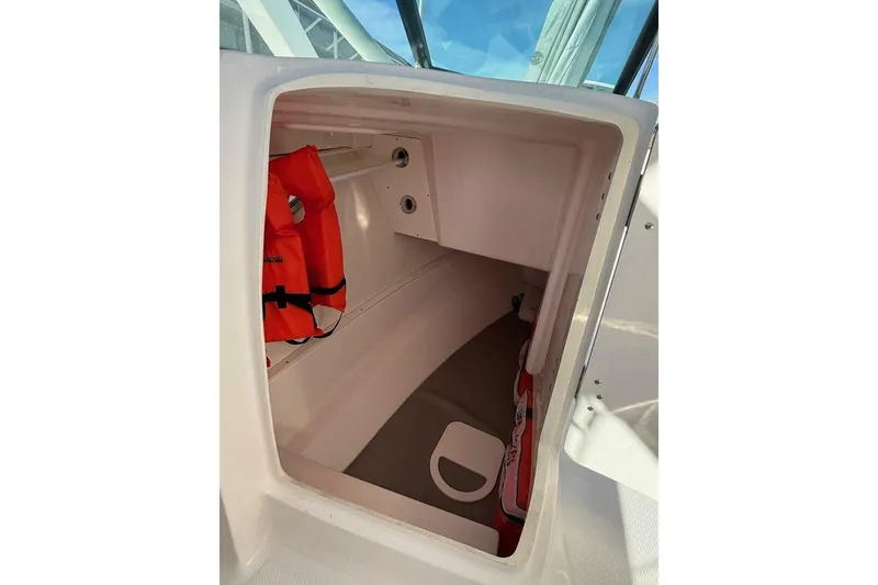 Slide: The Image of Storage compartment in 2021 Robalo R317 Dual Console boat with life jackets. - 13