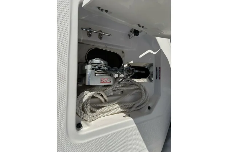 Slide: The Image of 2021 Robalo R317 Dual Console anchor compartment with rope and chain. - 16
