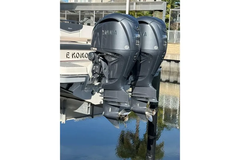 Slide: The Image of 2021 Robalo R317 Dual Console with twin Yamaha outboard engines, docked by the water. - 17