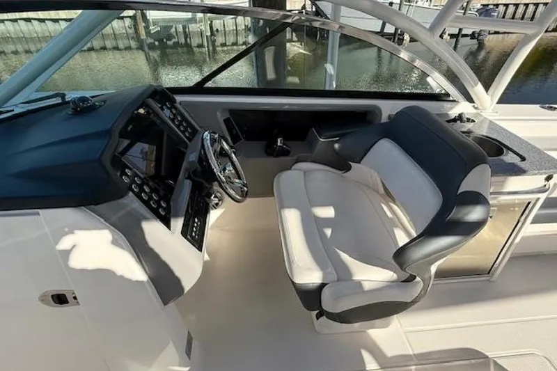 Slide: The Image of 2021 Robalo R317 Dual Console boat interior with steering wheel and seating. - 2