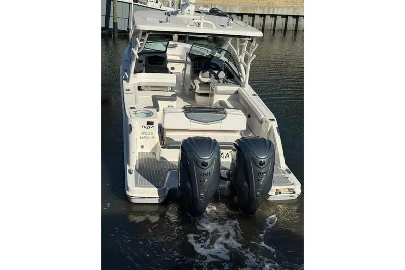 Slide: The Image of 2021 Robalo R317 Dual Console boat with twin engines, docked in calm water. - 22