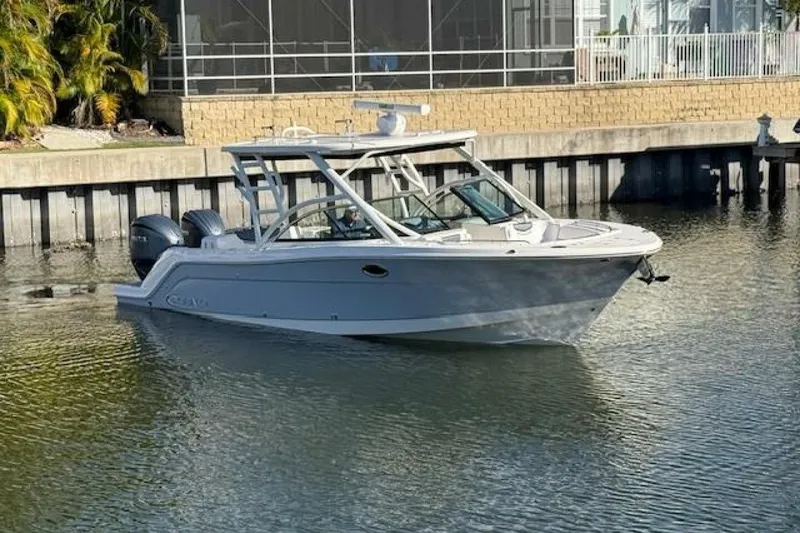 Slide: The Image of 2021 Robalo R317 Dual Console boat on calm water near a dock. - 25