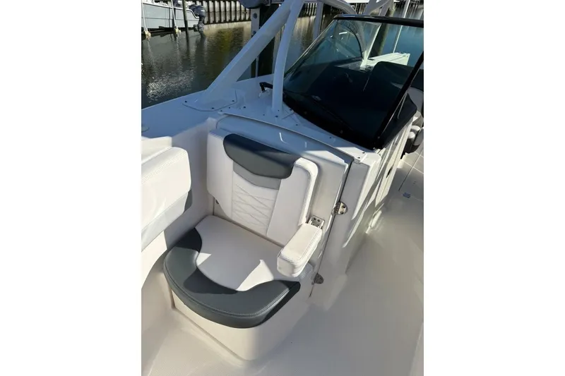 Slide: The Image of 2021 Robalo R317 Dual Console boat interior with cushioned seating and windshield. - 6